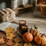 Warm indoor autumn scene with pumpkins and leaves on a wooden table.